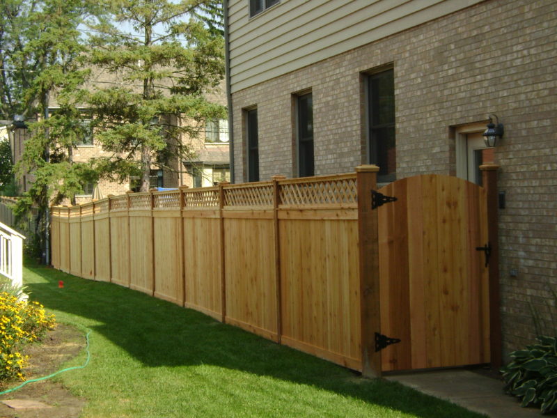 Photo of a custom traditional wood fence with a lattice topper designed and installed by First Fence Company
