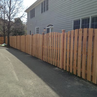 Photo of a custom board on board arched fence designed and installed by First Fence Company