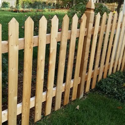 Photo of a point cut picket wood fence with French Gothic posts installed by First Fence Company