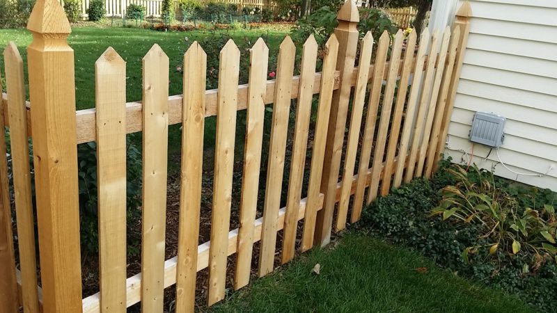 Photo of a point cut picket wood fence with French Gothic posts installed by First Fence Company