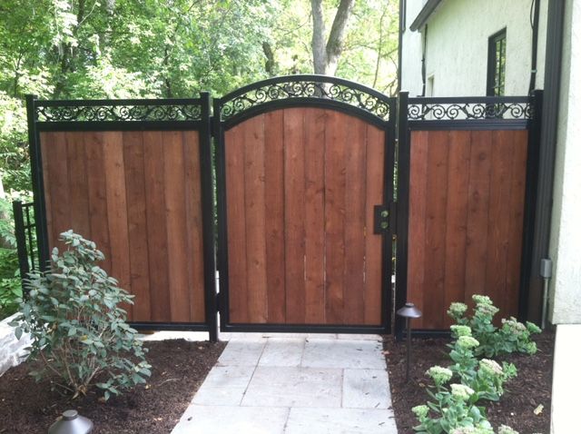 Photo of an iron and wood fence designed and installed by First Fence Company