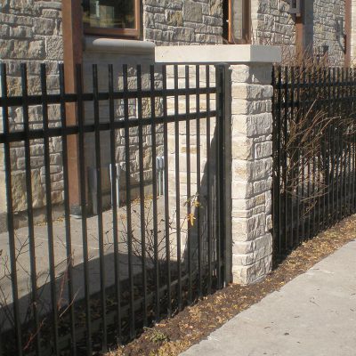Photo of a custom residential masonry iron fence installed by First Fence