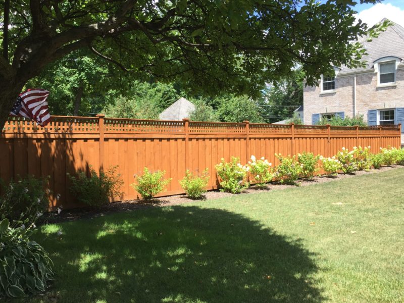 Photo of a custom pre-stained layered traditional wood fence installed by First Fence Company