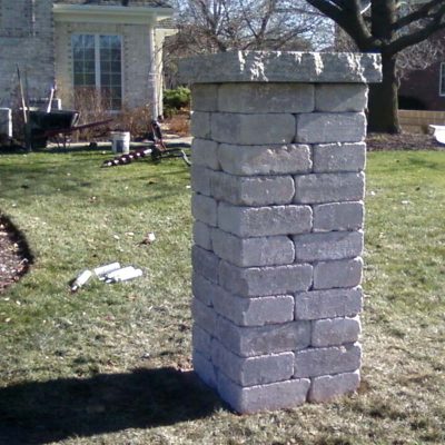 Photo of a stone pillar before First Fence Company installed a custom fence